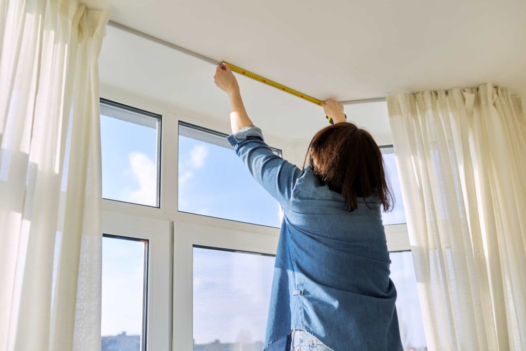 Woman measuring blinds | Featured image for How to Measure for Blinds Blog from U Blinds Australia.