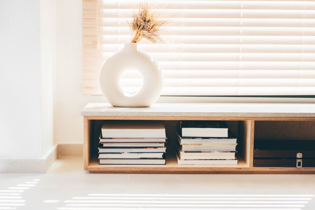 Horizontal bookcase with Neo-Modern Vase | Featured image for the History of Venetian Blinds Blog from U Blinds Australia.