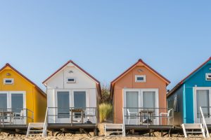 Coloured Beach Houses in the Sand | Featured image for Beach House Blinds Blog by U Blinds Australia