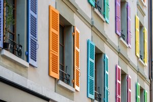 Image of Multicoloured Window Shutters on Apartment Building | Featured image for Choosing Coloured Shutters for Your Home Blog by U Blinds Australia.