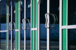Row of glass panelled doors with green frames | Featured Image for the Adding Value to Your Home with Security Doors blog by U Blinds Australia