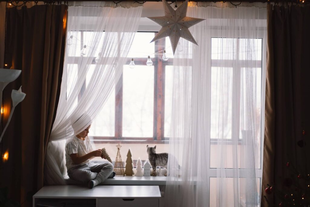 boy playing underneath curtains | Featured Image for the Blinds Northern Beaches Sydney page from U Blinds Australia.