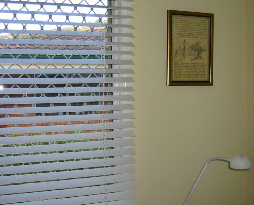 White blinds next to a wall picture | Featured Image for the Timber Venetian Blinds page of U Blinds Australia.