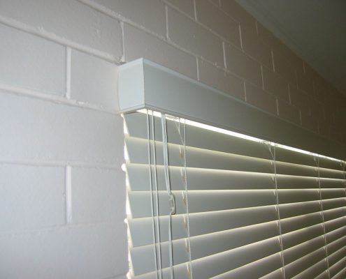 A close up view of blinds and a white brick wall | Featured Image for the Timber Venetian Blinds page of U Blinds Australia.