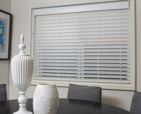 Blinds behind a table with two vases | Featured Image for the Timber Venetian Blinds page of U Blinds Australia.