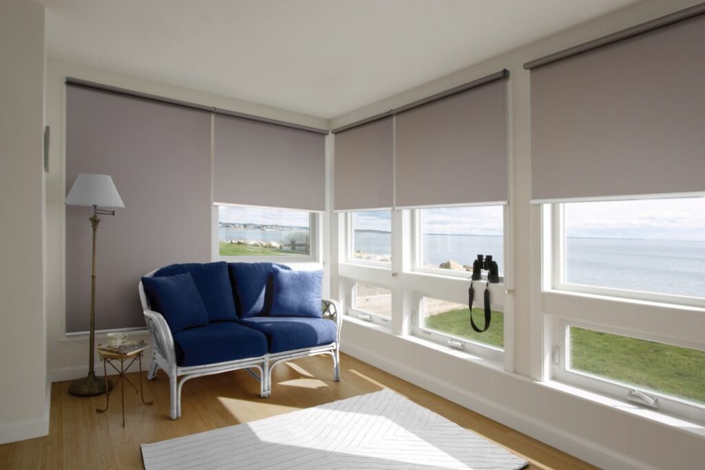 Blinds in a white walled room with light brown flooring with windows facing the ocean | Featured Image for the Adelaide Loaction Page of U Blinds Australia.