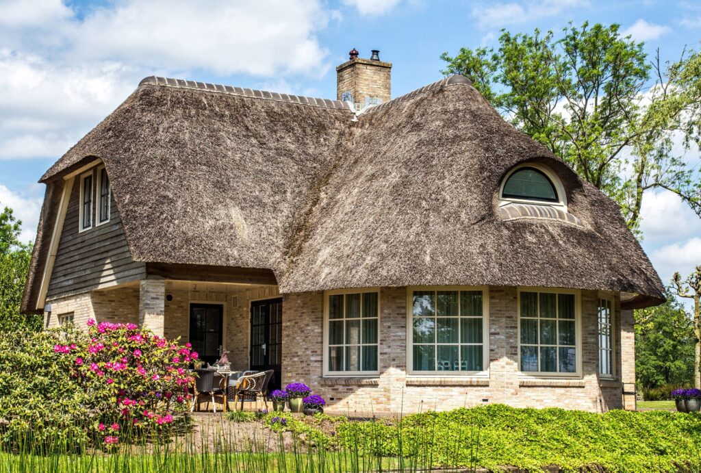 Traditional cottage with a thatched roof | Featured Image for the Cottage Style Window Treatments Blog by U Blinds Australia.