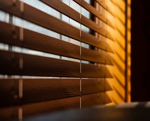 Wooden blinds filtering light inside | Featured Image for the Interior Blinds Page of U Blinds Australia.